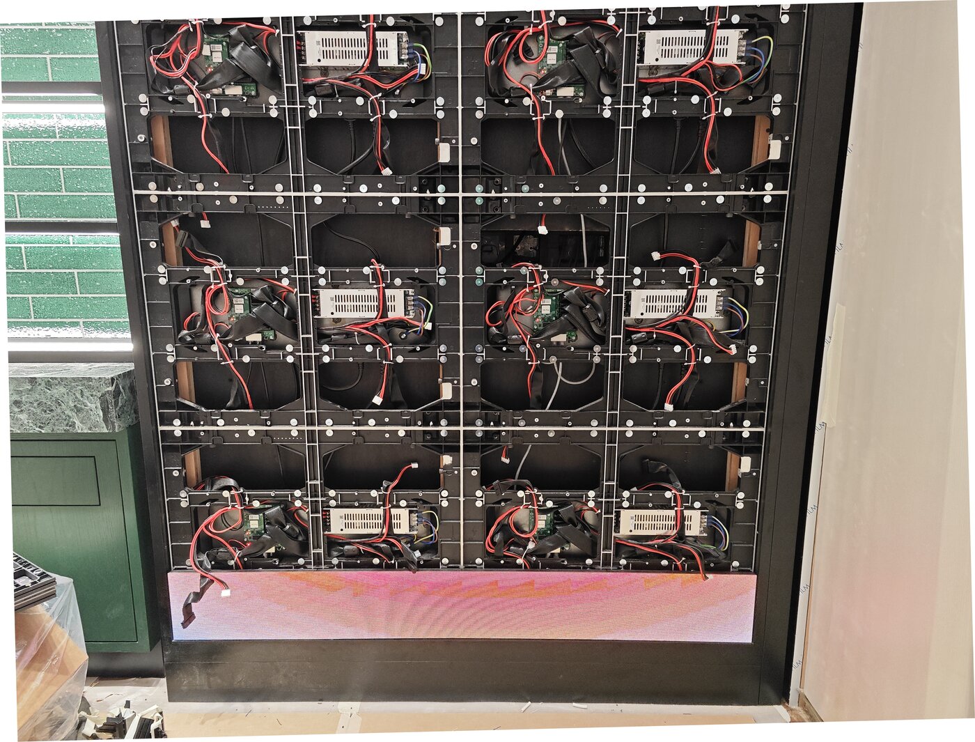 安裝中的 LED 視像牆框架與模組，底排亮燈